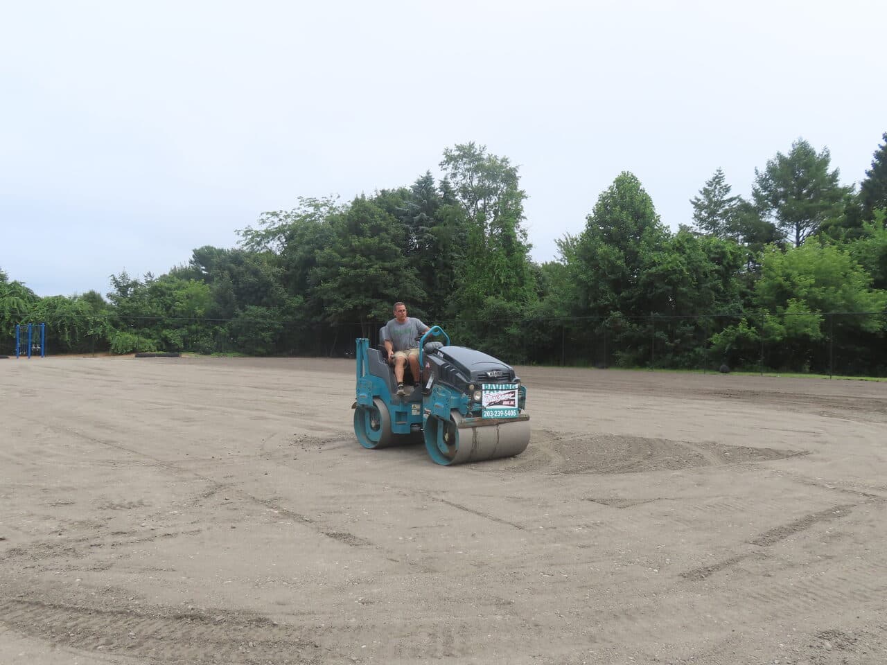 Athletic Facility Parking Lot Paving project in Rhode Island, RI — roller compacting graded lot
