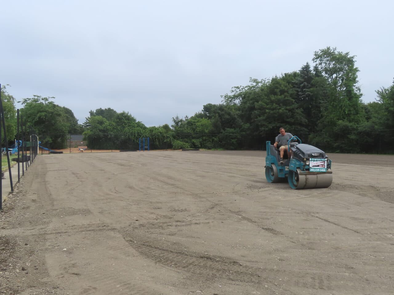 Athletic Facility Parking Lot Paving project in Rhode Island, RI — roller compacting wide lot view
