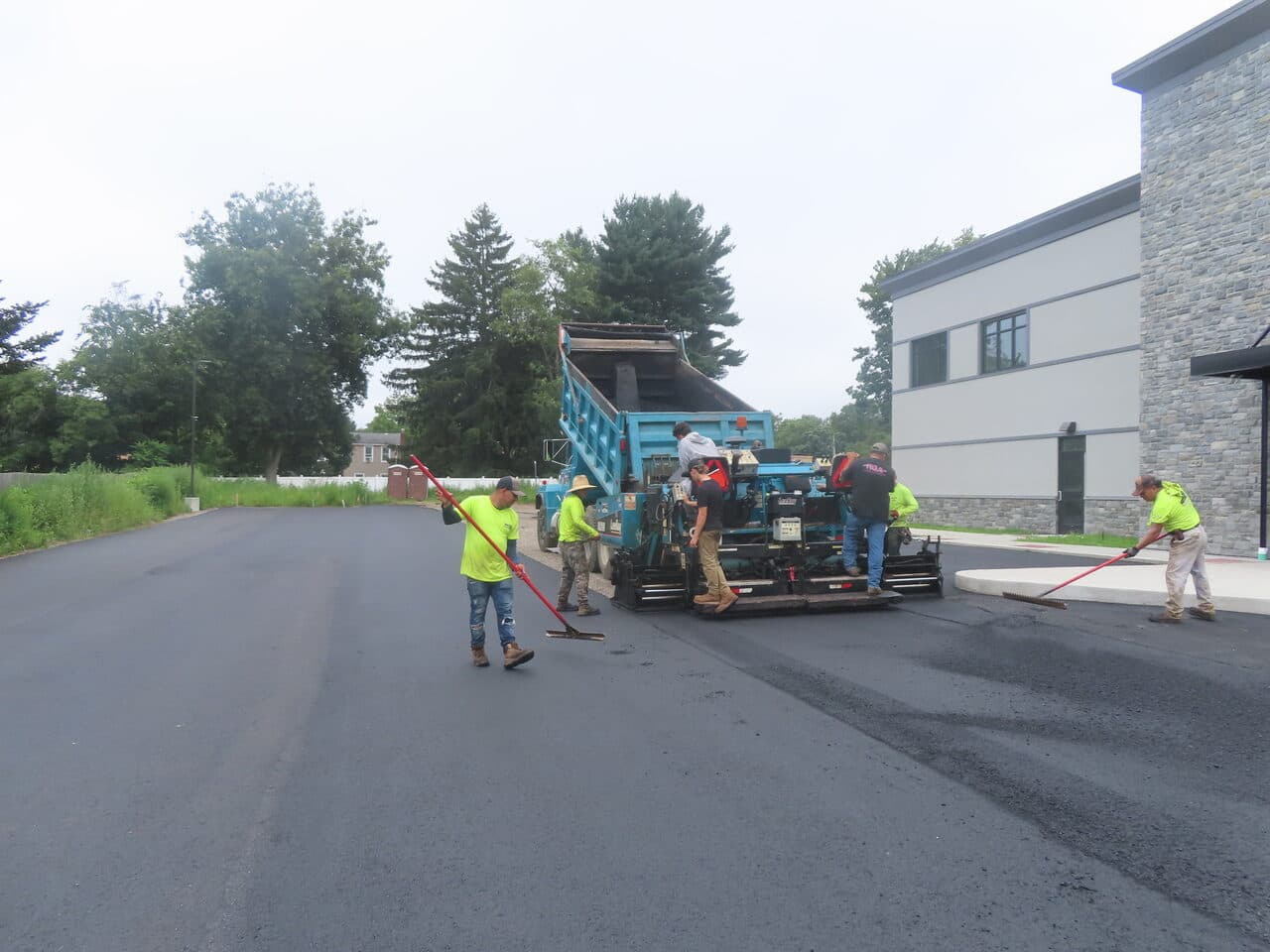 Commercial Parking Lot Paving project in Orange, CT — paving crew laying asphalt at commercial building