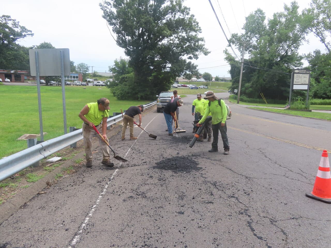 Commercial Parking Lot Paving project in Orange, CT — crew raking patch material on road