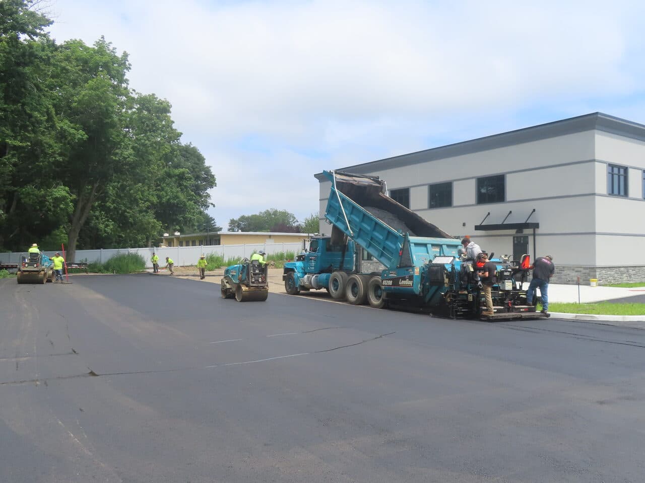 Commercial Parking Lot Paving project in Orange, CT — paving train with roller at office building