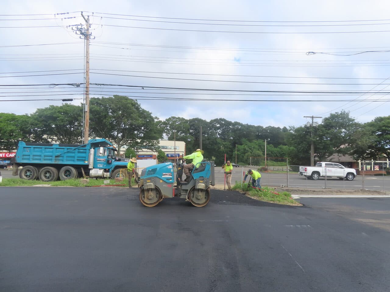 Commercial Parking Lot Paving project in Orange, CT — roller compacting fresh asphalt entrance
