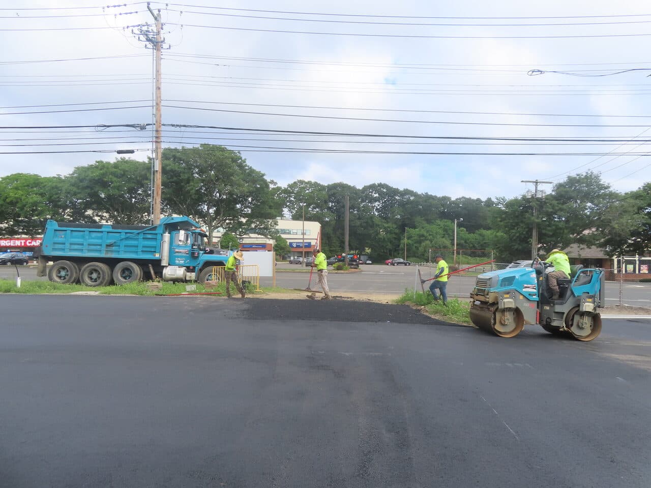 Commercial Parking Lot Paving project in Orange, CT — roller compacting new lot edge