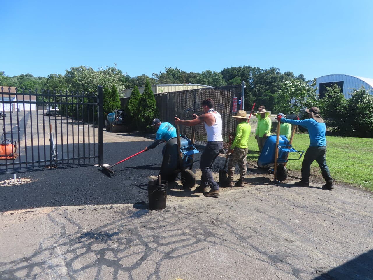 Commercial Parking Lot Repair & Patching project in Wallingford, CT — crew paving apron at gate entrance