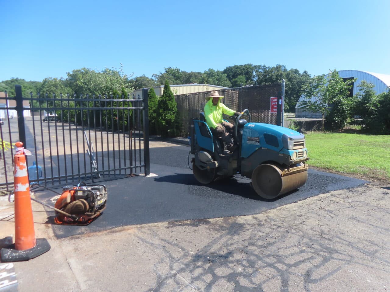 Commercial Parking Lot Repair & Patching project in Wallingford, CT — roller compacting asphalt at gate