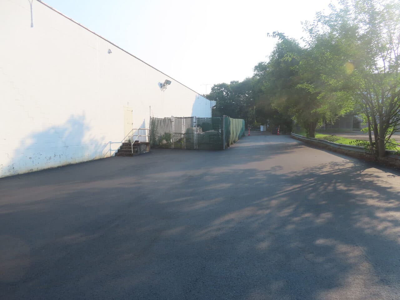 Commercial Parking Lot Paving project in Branford, CT — finished asphalt by white building