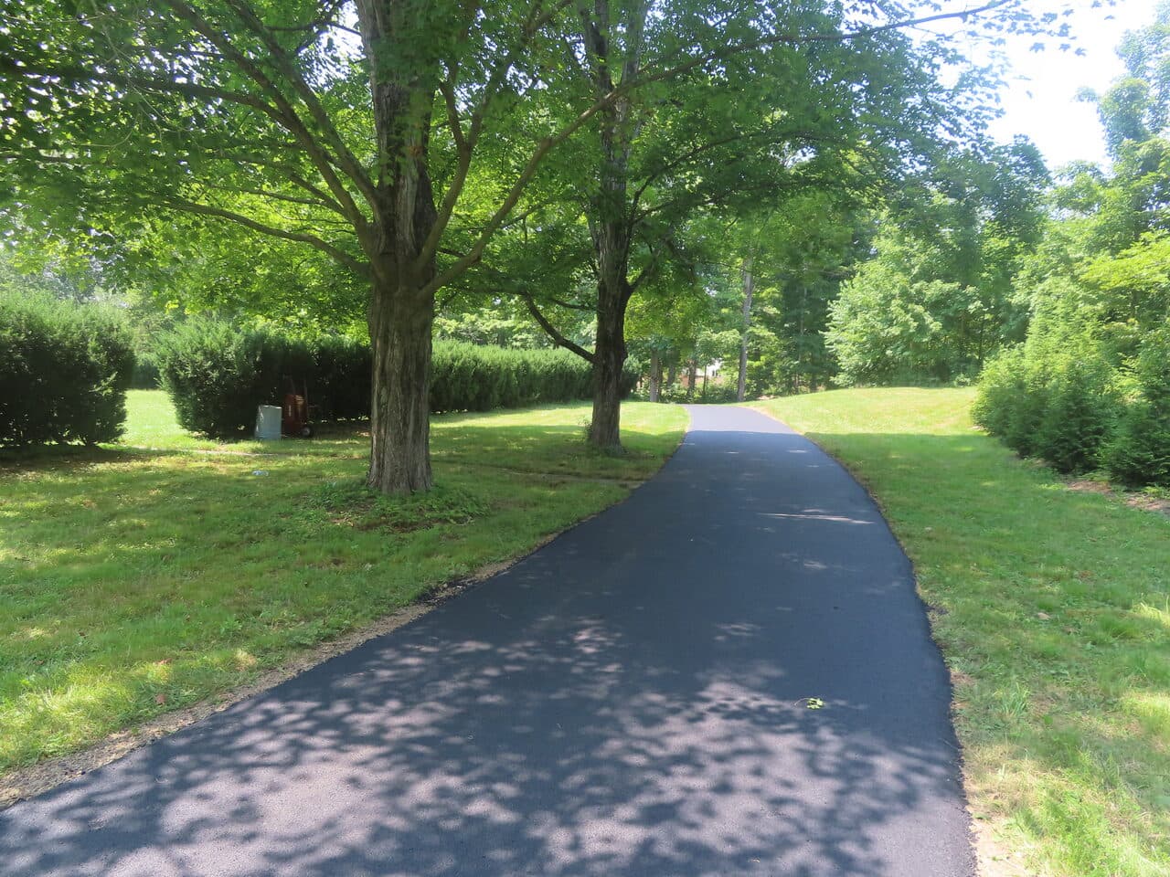 Pedestrian Trail & Parking Lot Paving project in Guilford, CT — curving paved drive with hedges