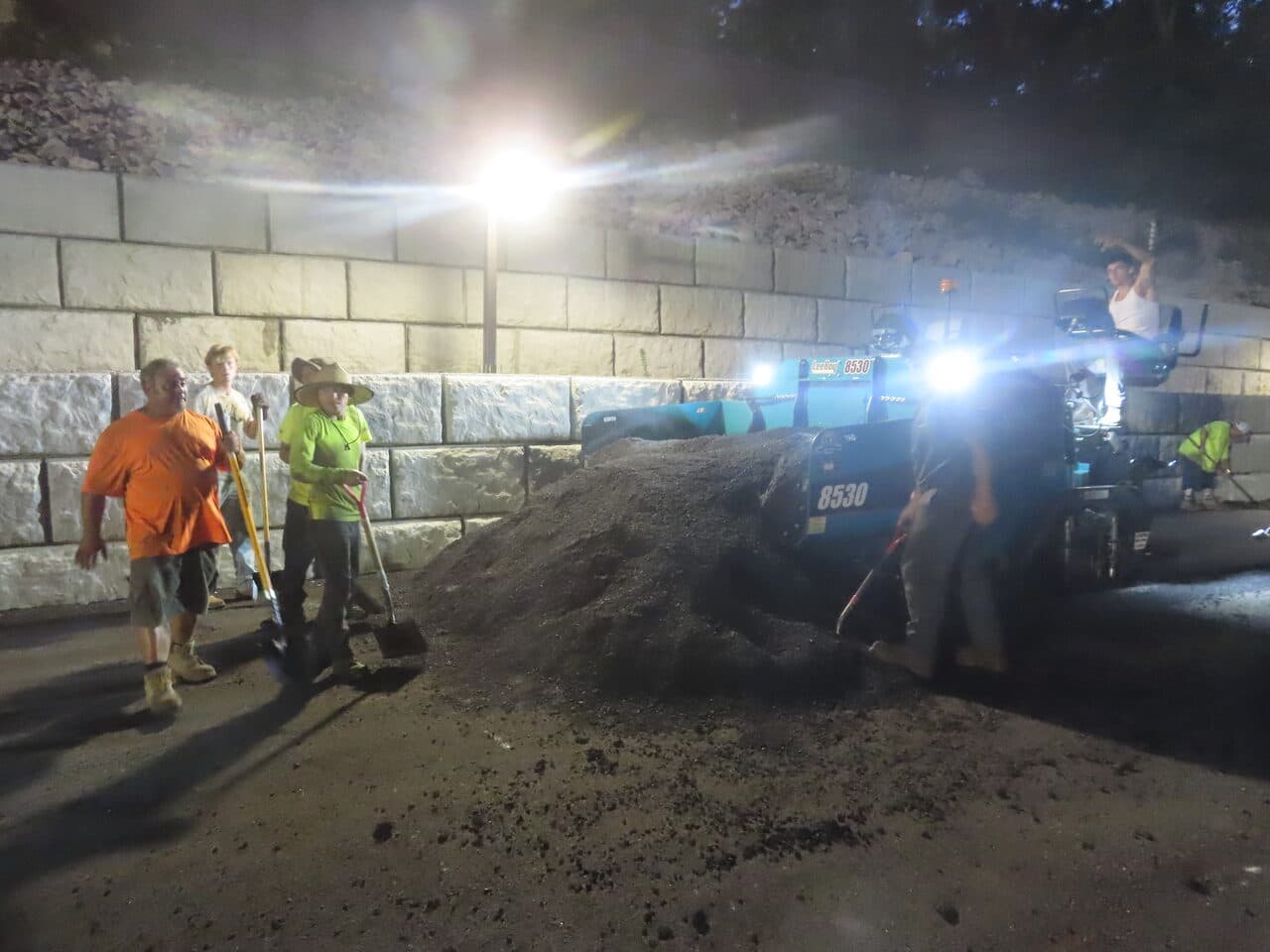 Commercial Parking Lot Paving project in Guilford, CT — crew with paver behind retaining wall