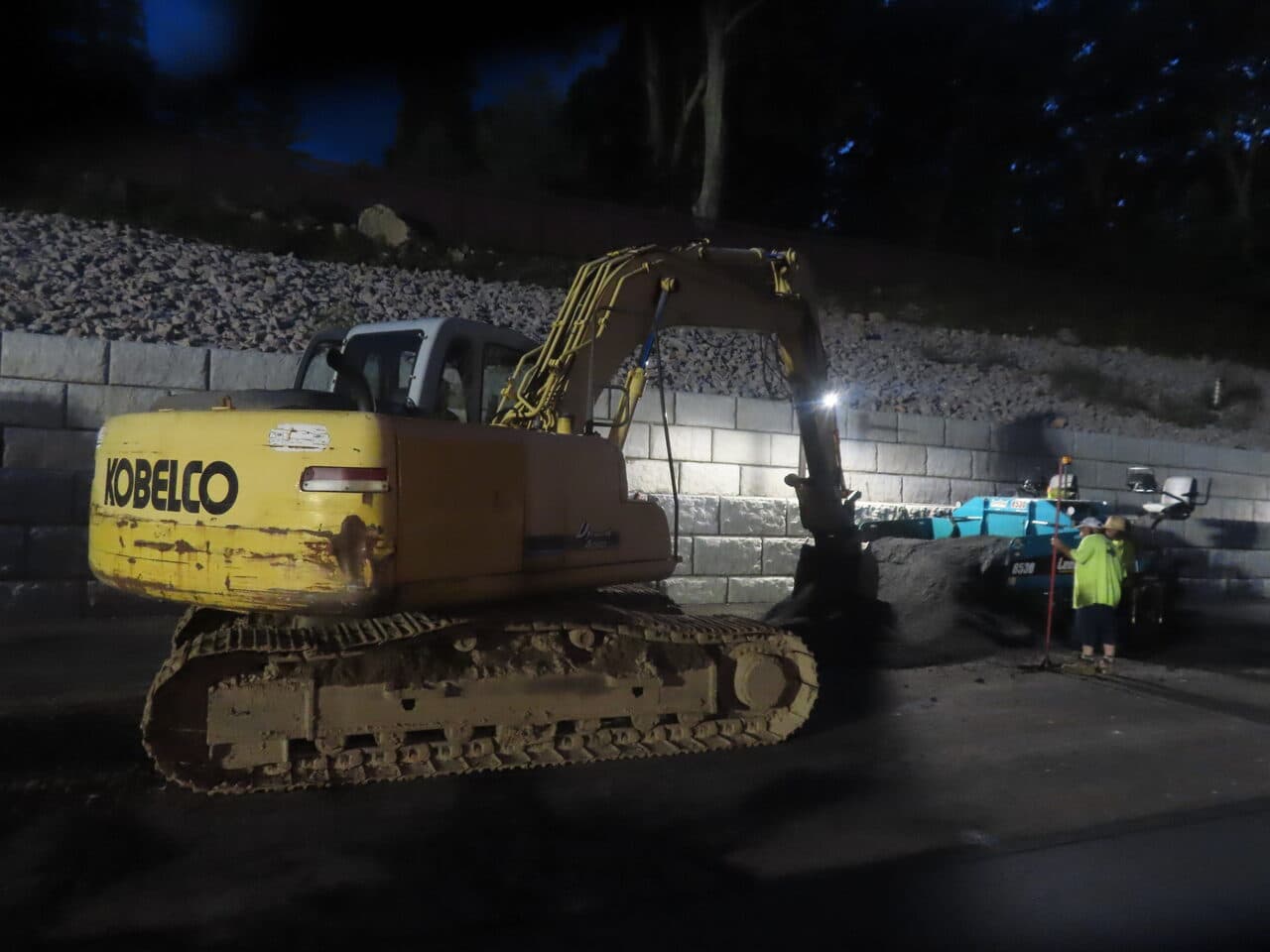 Commercial Parking Lot Paving project in Guilford, CT — Kobelco excavator at night