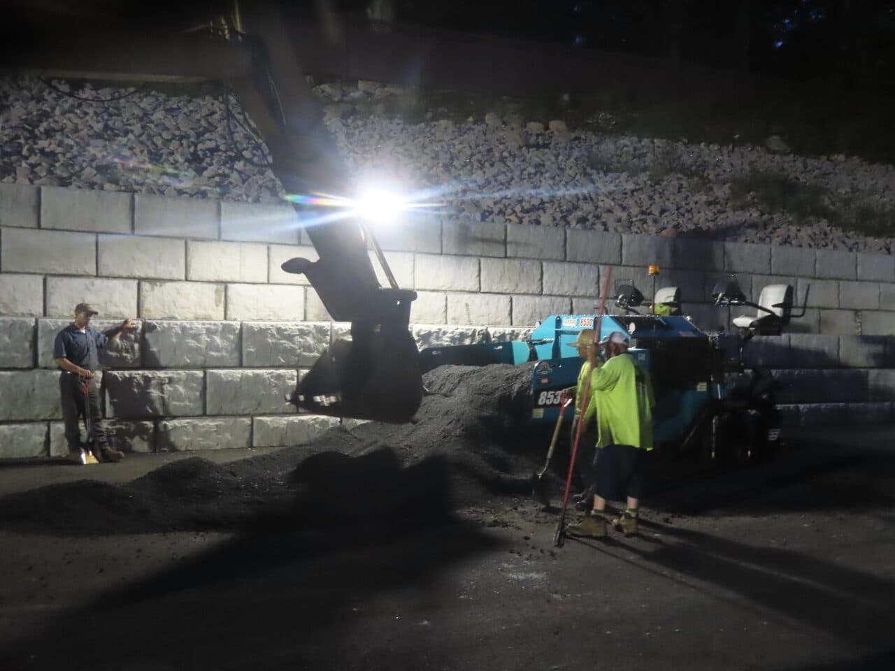 Commercial Parking Lot Paving project in Guilford, CT — excavator loading paver with crew