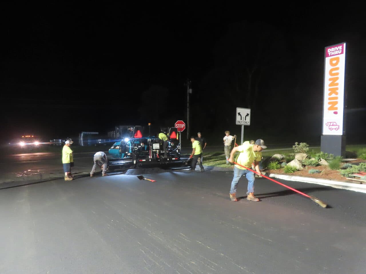Commercial Parking Lot Paving project in Guilford, CT — crew paving by Dunkin drive thru sign