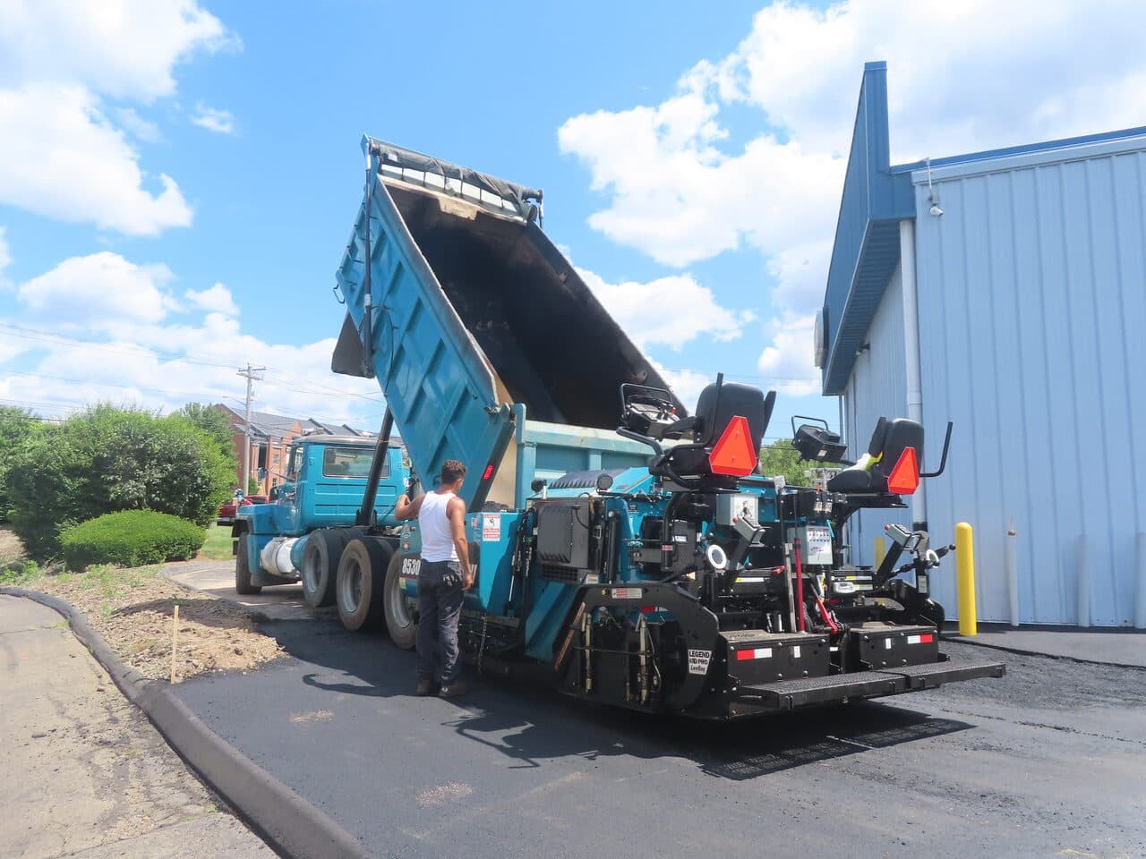 Commercial Parking Lot Paving project in North Haven, CT — dump truck loading paver hopper