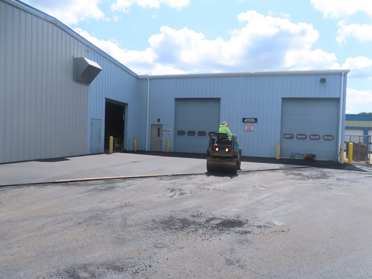 Commercial Parking Lot Paving project in North Haven, CT — roller compacting near loading docks
