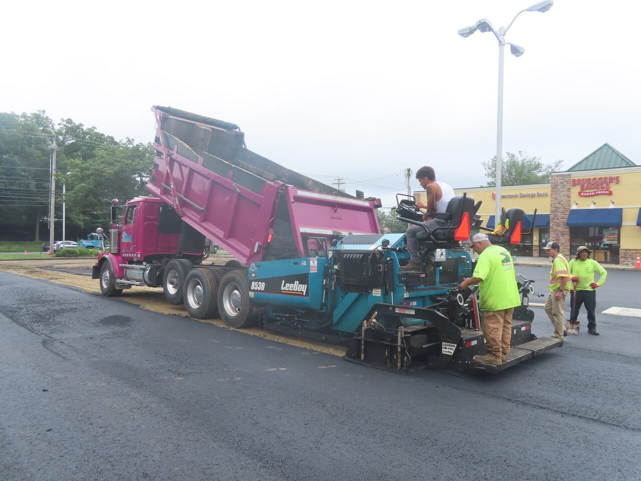 Commercial Parking Lot Paving project in Shelton, CT — paver and dump truck laying asphalt