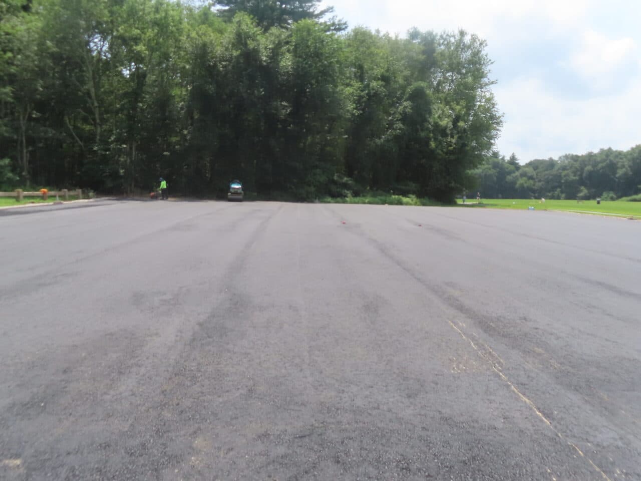 Commercial Parking Lot Paving project in Brooklyn, CT — finished asphalt lot by woods