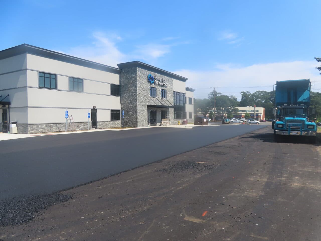 Commercial Parking Lot Paving project in Orange, CT — wide finished asphalt lot and building