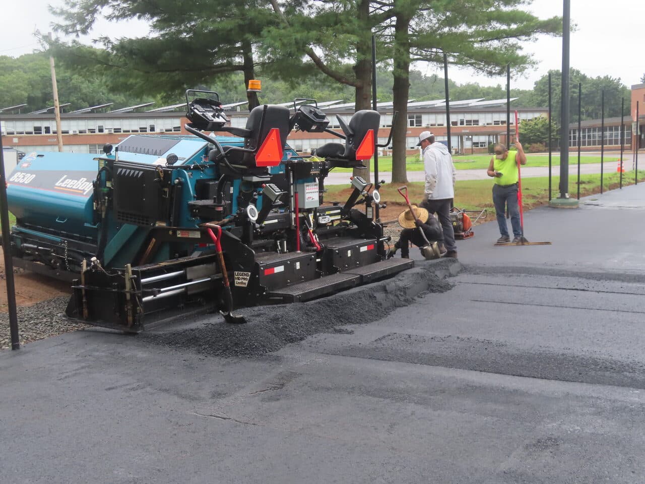 Commercial Parking Lot Paving project in East Haven, CT — paver laying asphalt mat closeup