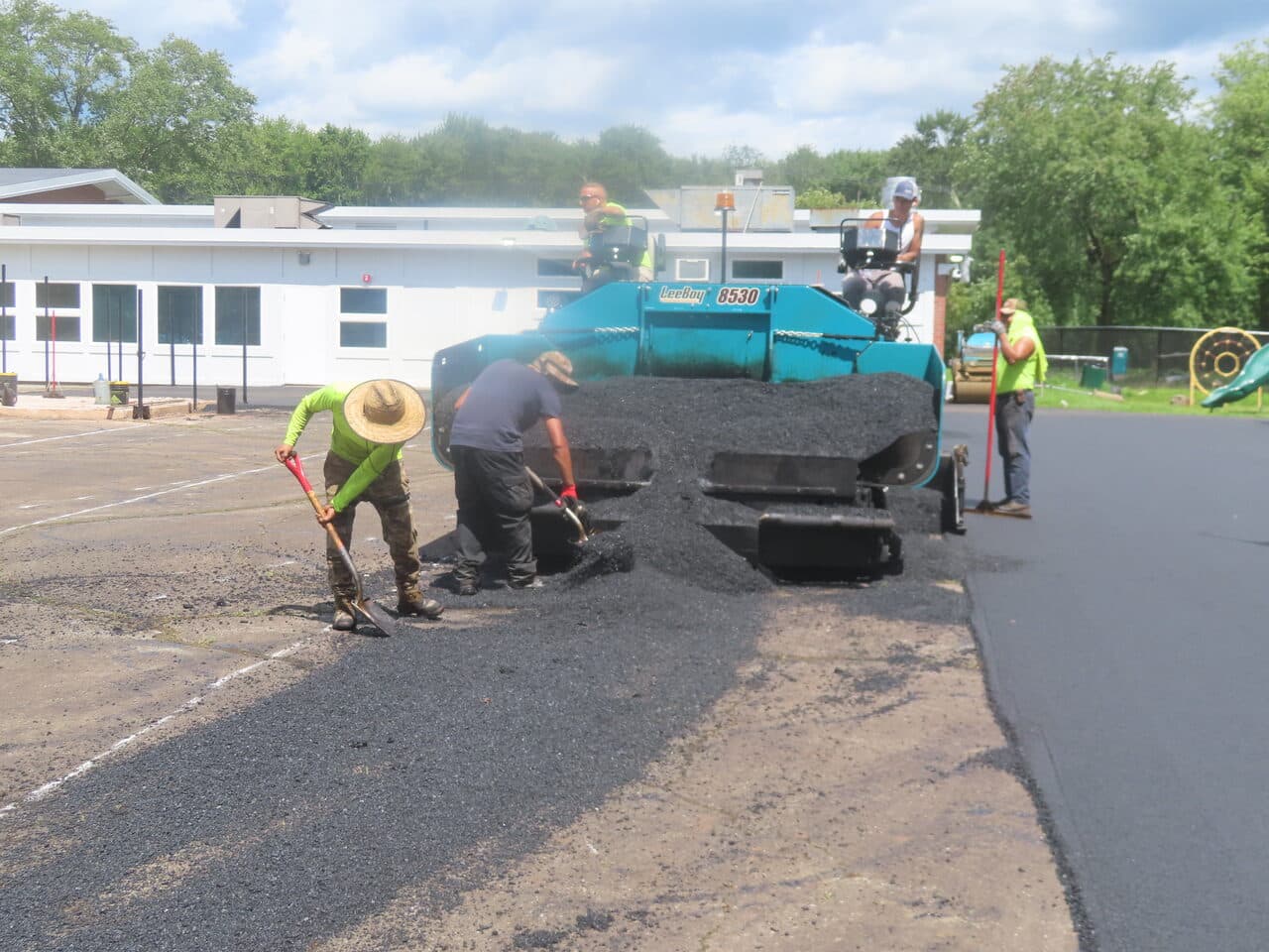 Commercial Parking Lot Paving project in Bloomfield, CT — crew raking asphalt behind paver