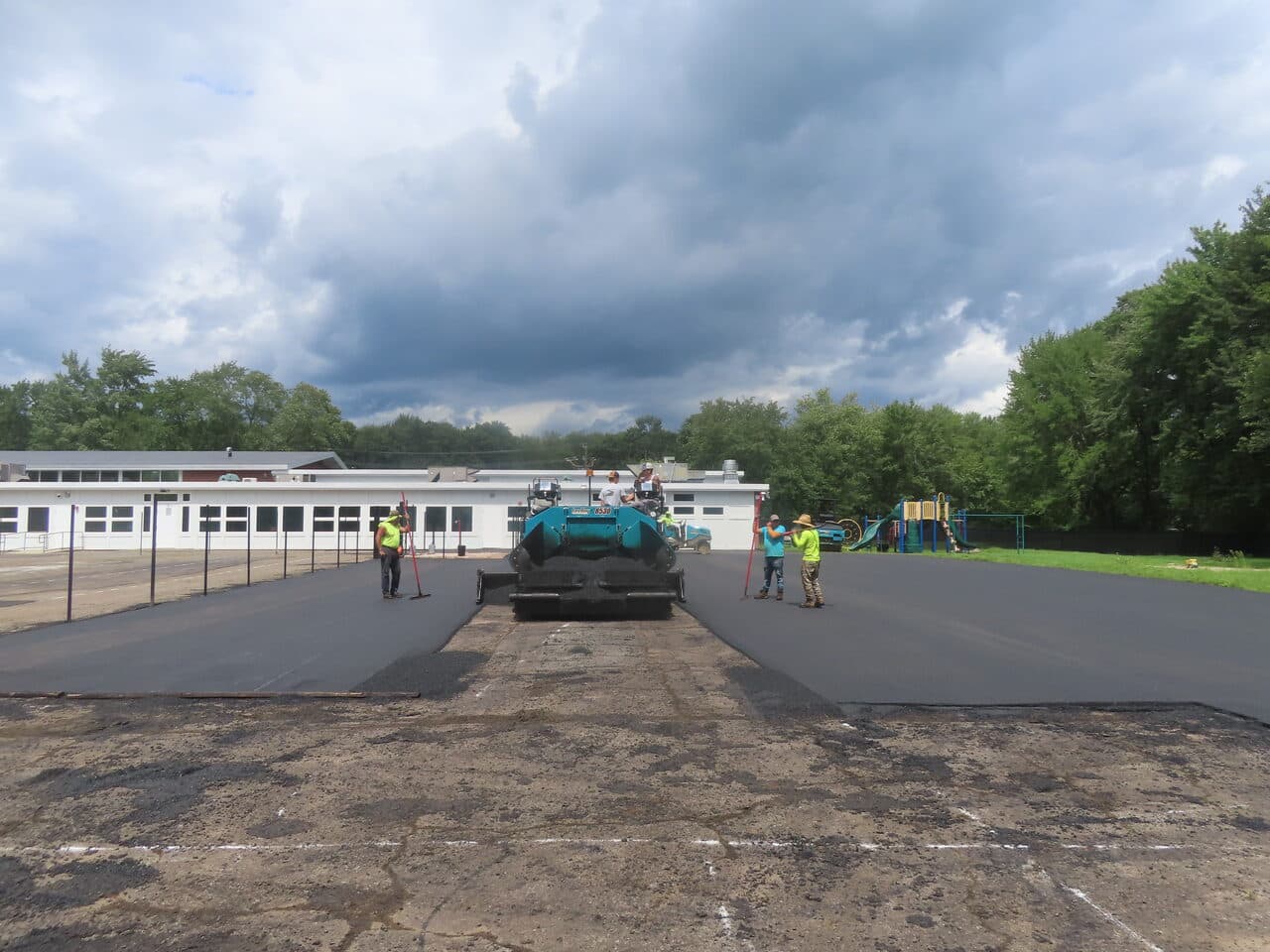 Commercial Parking Lot Paving project in Bloomfield, CT — paver laying asphalt under cloudy sky