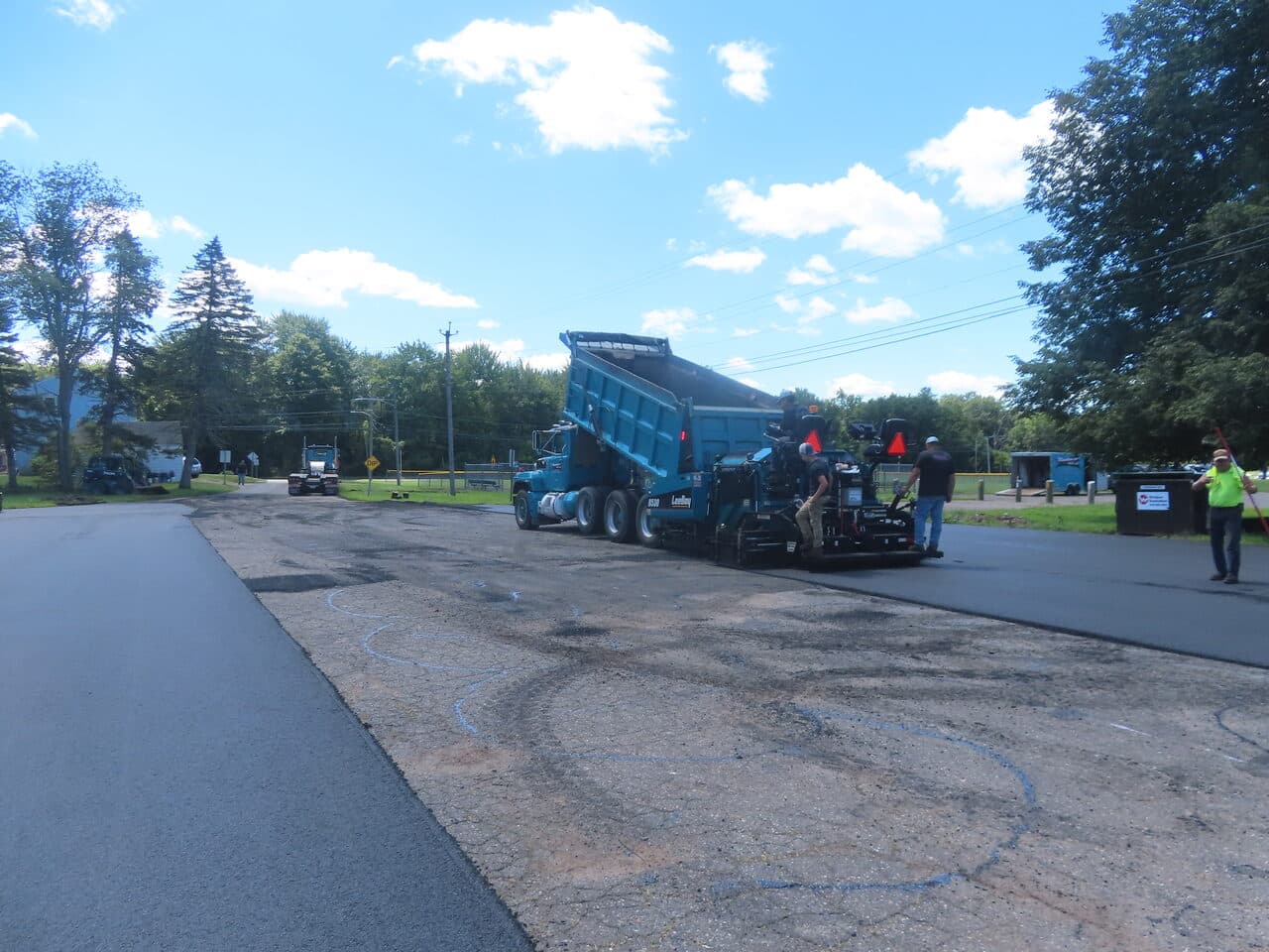 Commercial Parking Lot Paving project in Bloomfield, CT — paver and dump truck laying asphalt