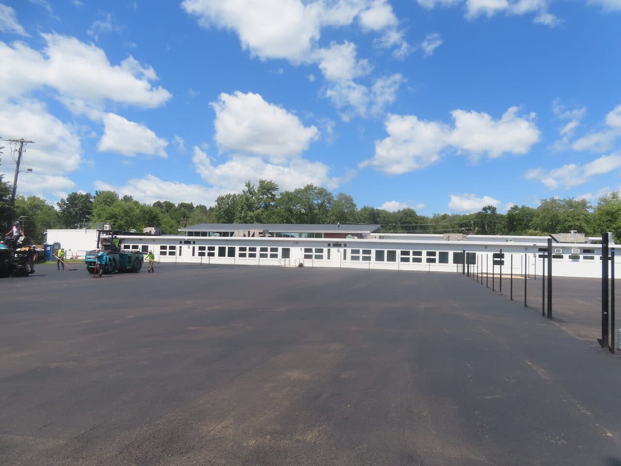 After — Commercial Parking Lot Paving in Bloomfield, CT (crew raking asphalt at intersection)