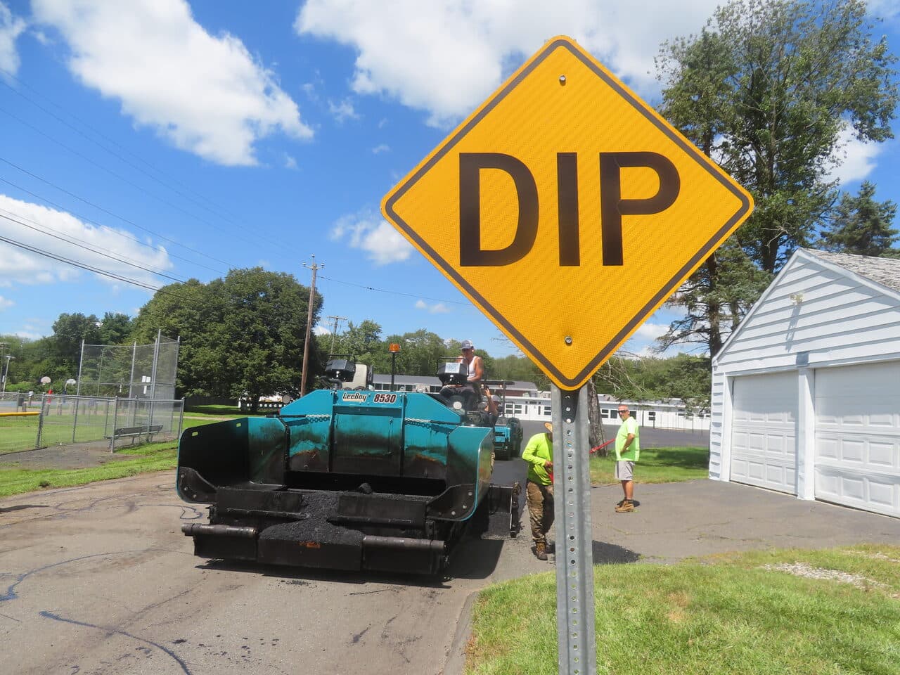 Commercial Parking Lot Paving project in Bloomfield, CT — paver behind DIP sign closeup