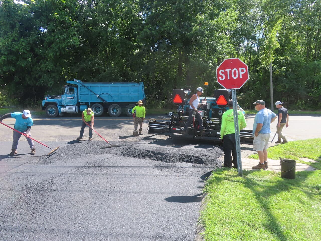 Before — Commercial Parking Lot Paving in Bloomfield, CT (crew raking asphalt at intersection)
