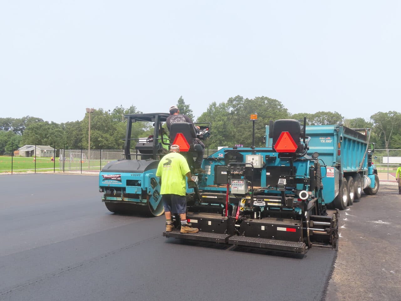 Commercial Parking Lot Paving project in Brooklyn, CT — paver and dump truck close up