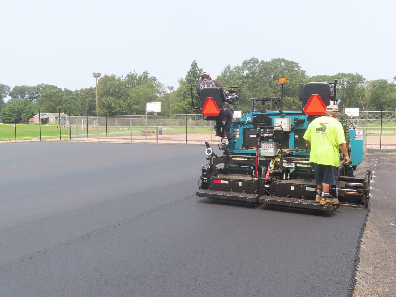 Commercial Parking Lot Paving project in Brooklyn, CT — paver laying fresh asphalt rear view