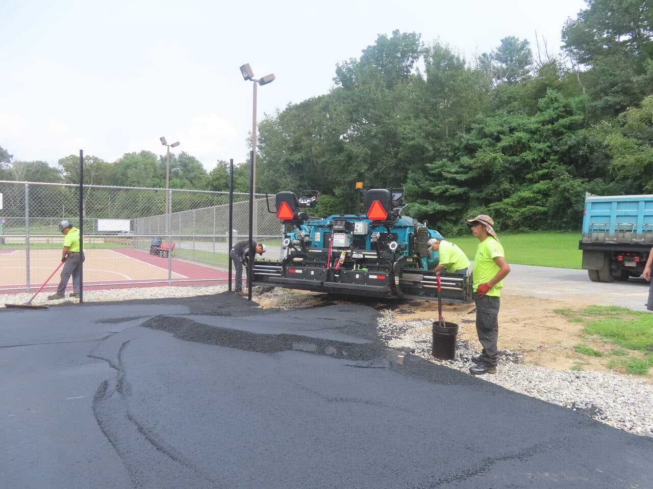Commercial Parking Lot Paving project in Brooklyn, CT — crew paving edge near basketball court