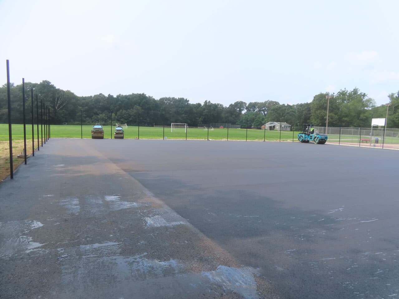 Commercial Parking Lot Paving project in Brooklyn, CT — finished asphalt lot with rollers