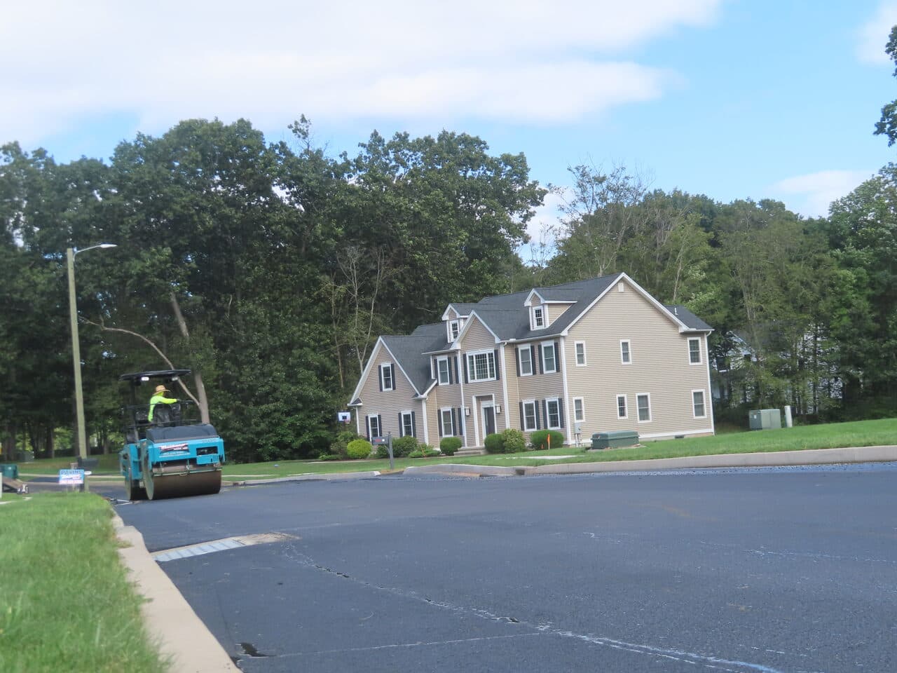Roadway Paving project in Cheshire, CT — roller near large home