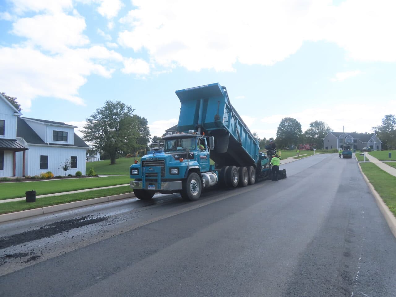 Roadway Paving project in Cheshire, CT — blue dump truck feeding paver