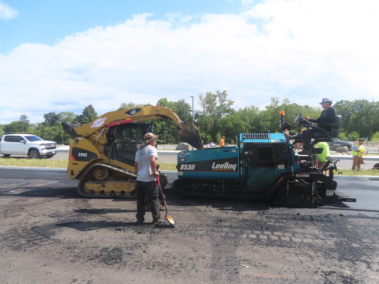 Commercial Parking Lot Paving project in Brookfield, CT — paver and skid steer laying asphalt