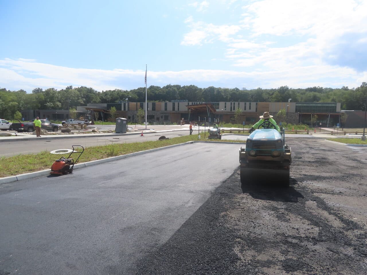 Commercial Parking Lot Paving project in Brookfield, CT — roller compacting fresh asphalt lot