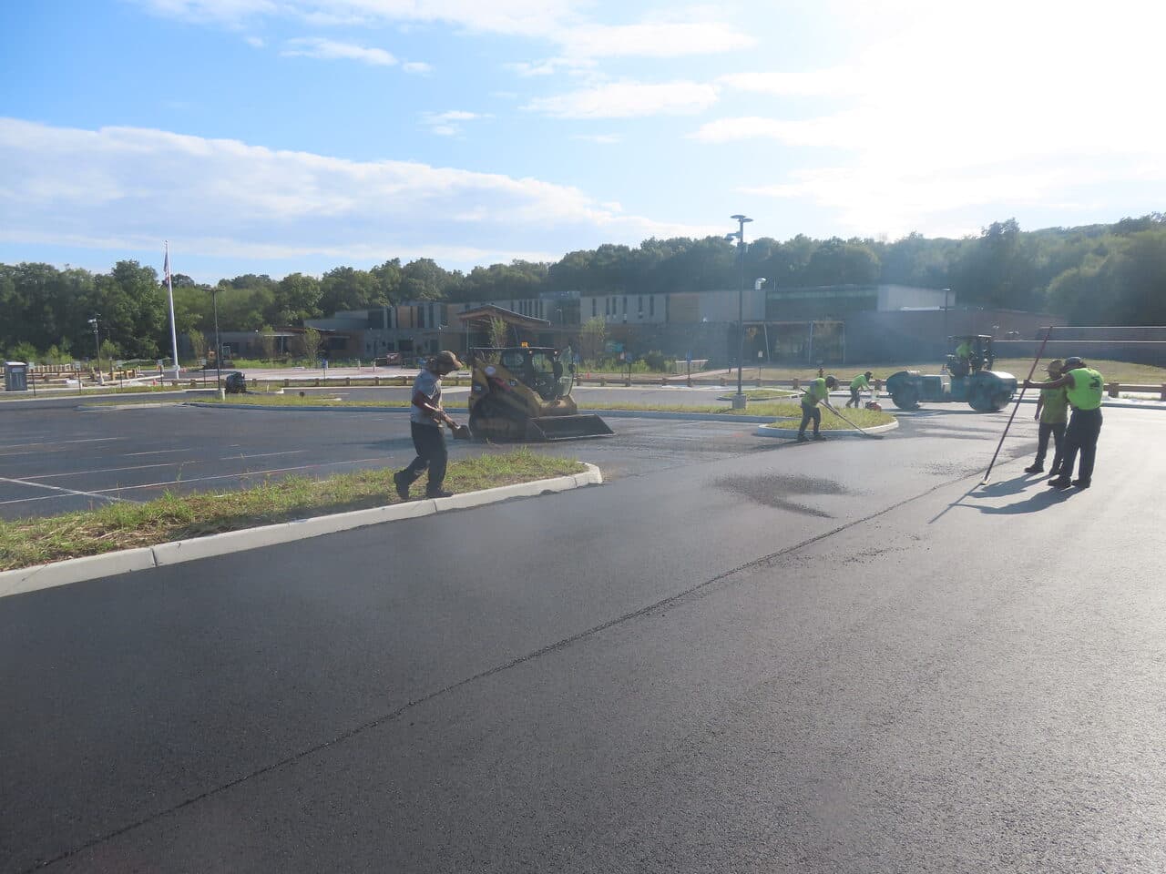 Commercial Parking Lot Paving project in Brookfield, CT — crew grading islands with skid steer