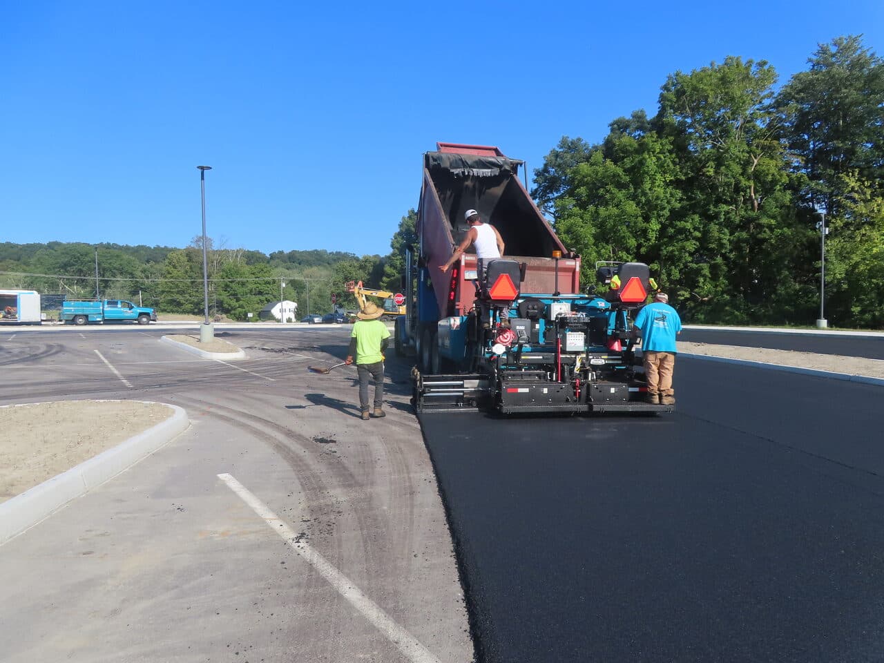 Commercial Parking Lot Paving project in Brookfield, CT — paver and dump truck laying asphalt