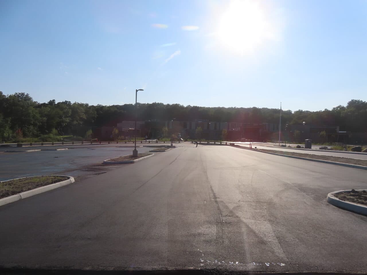 Commercial Parking Lot Paving project in Brookfield, CT — finished lot facing building backlit