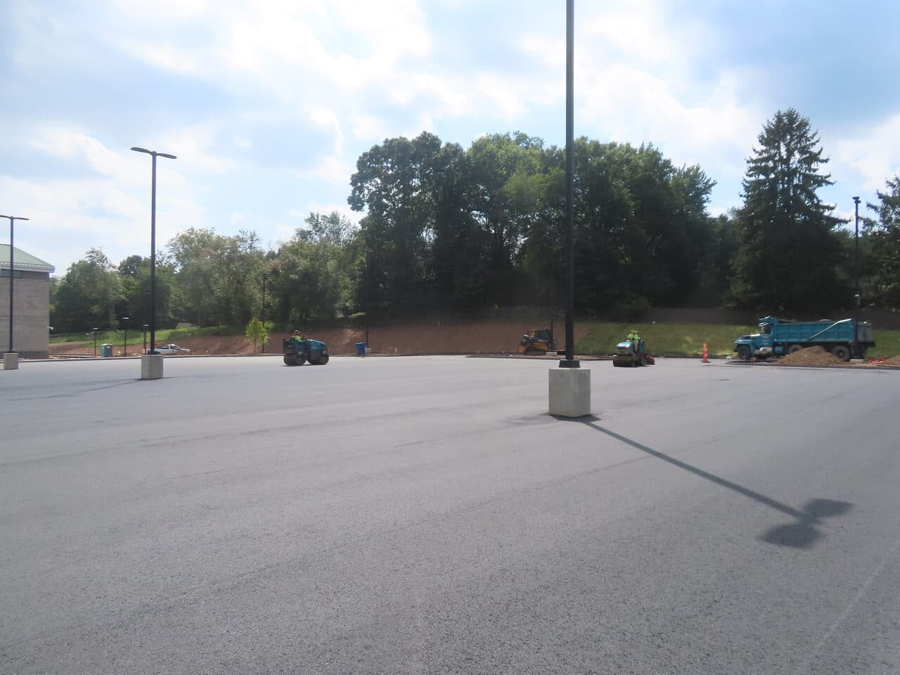 Commercial Parking Lot Paving project in North Branford, CT — finished lot with rollers in distance