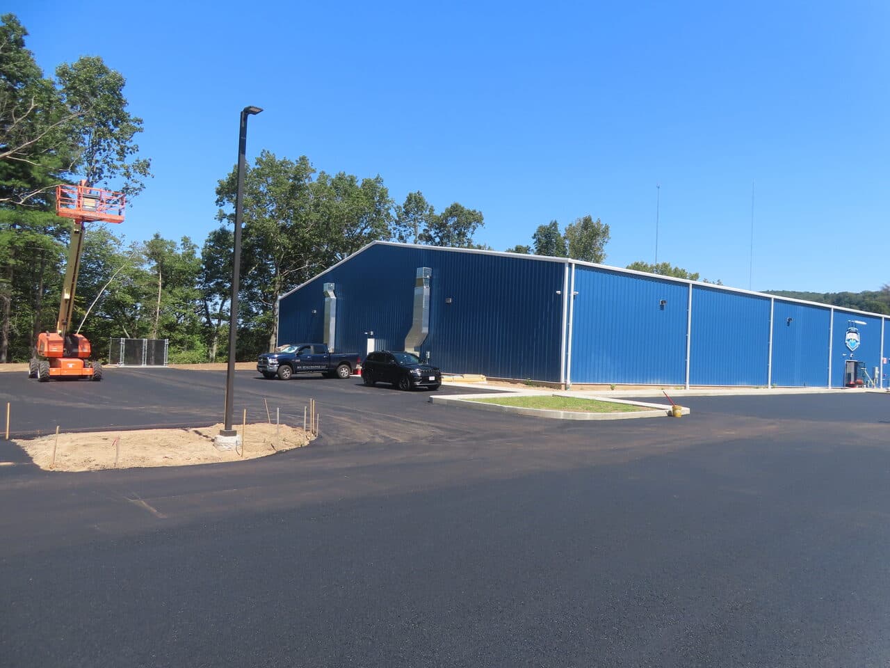 Commercial Parking Lot Paving project in Plainville, CT — finished lot with building and lift