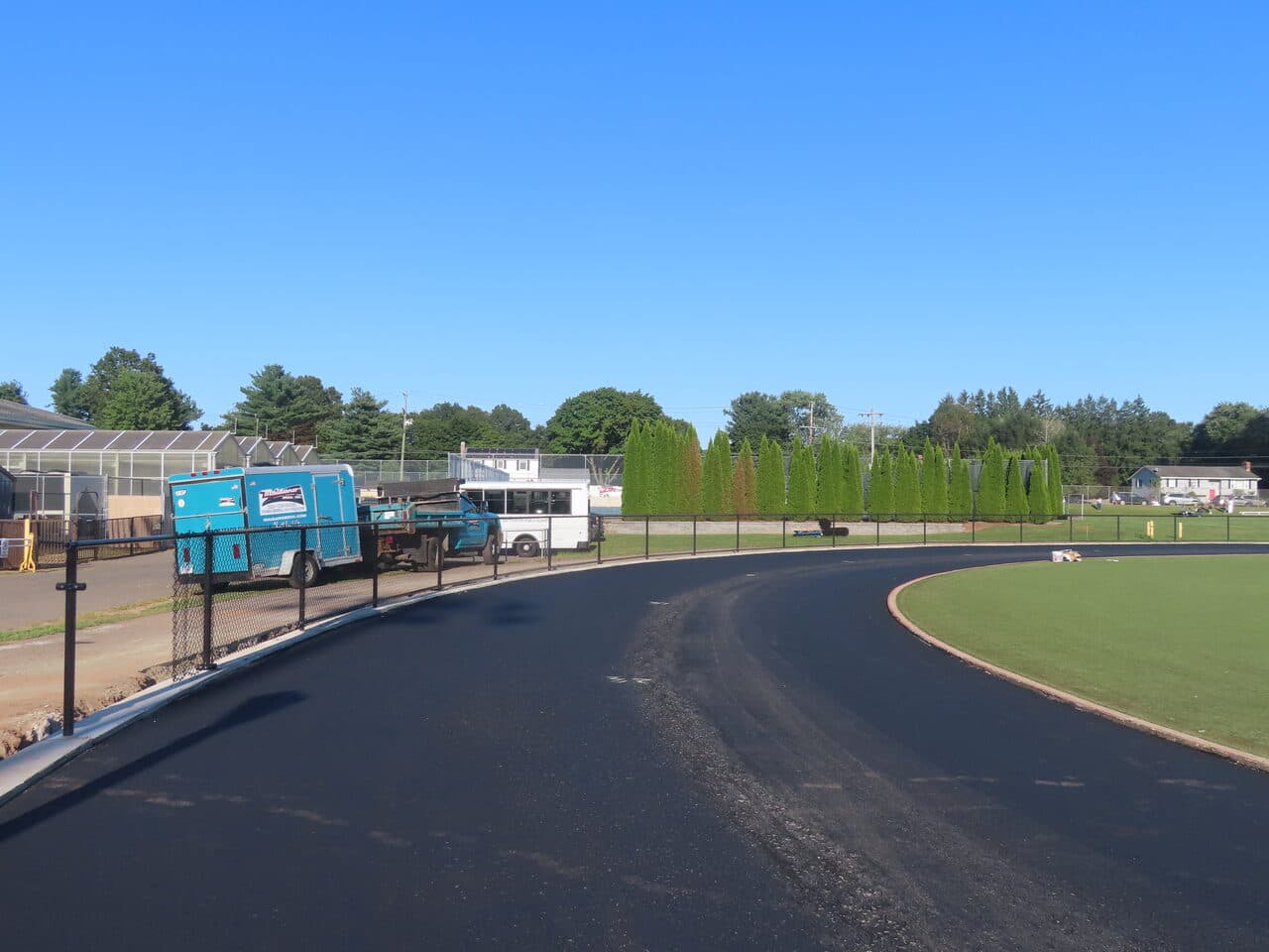 Athletic Surface Base Paving project in Southington, CT — finished track curve by field