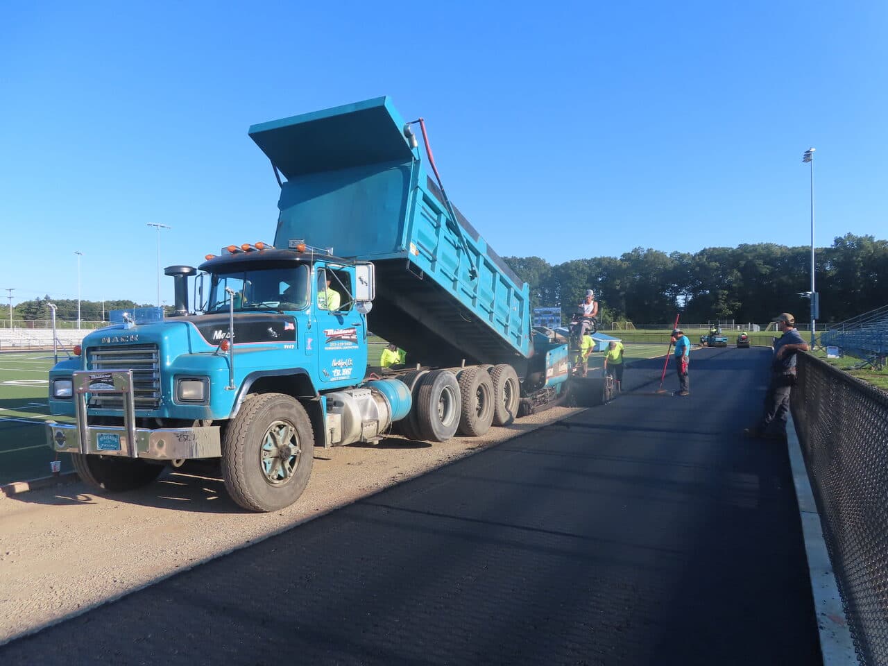Athletic Surface Base Paving project in Southington, CT — crew paving track with truck