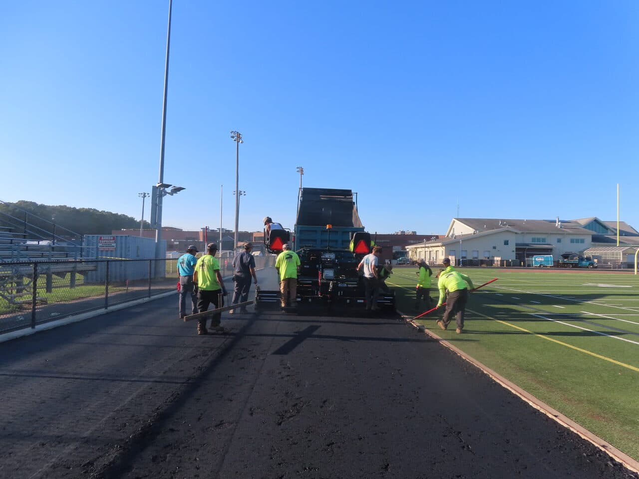 Athletic Surface Base Paving project in Southington, CT — paving crew working track