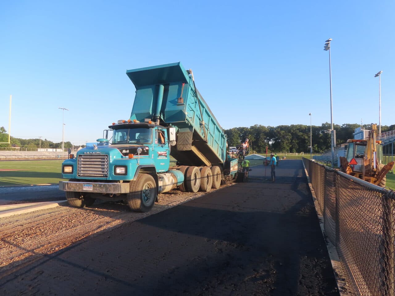Athletic Surface Base Paving project in Southington, CT — dump truck dumping base material