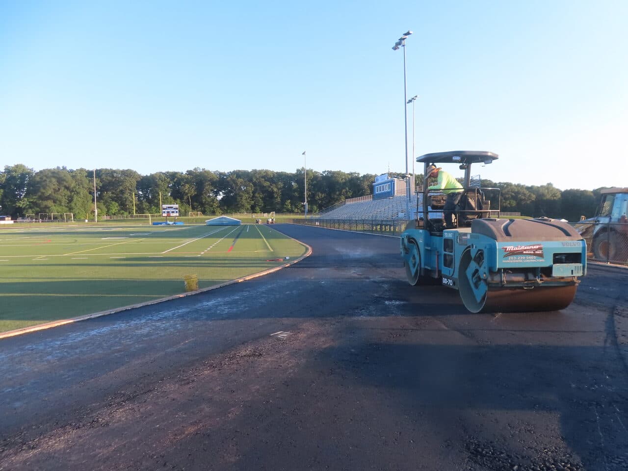 Athletic Surface Base Paving project in Southington, CT — roller compacting track base