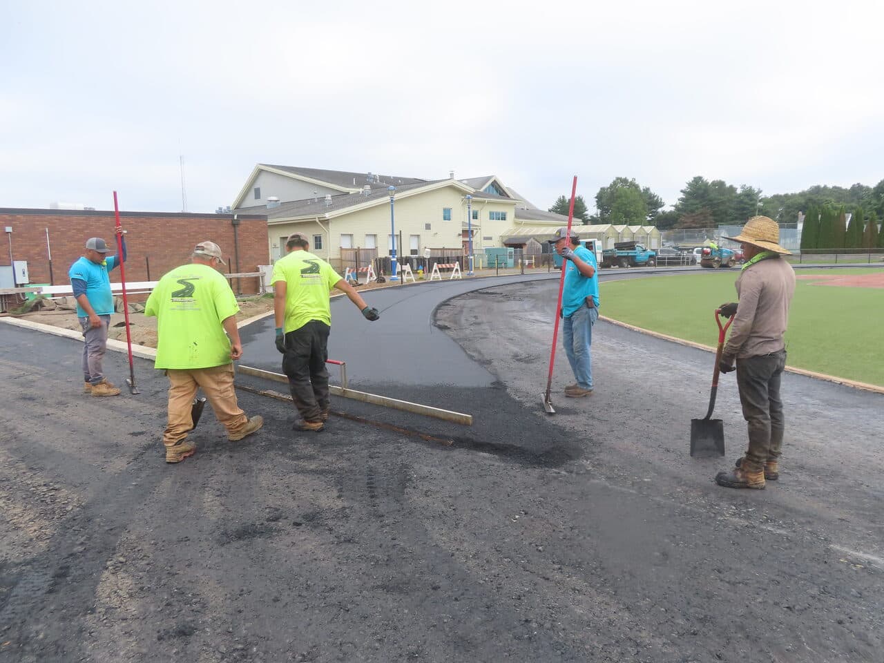 Athletic Surface Base Paving project in Southington, CT — crew finishing asphalt curve