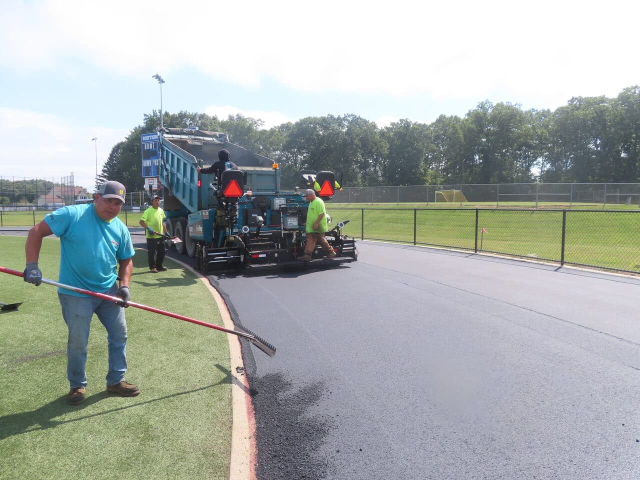 Athletic Surface Base Paving project in Southington, CT — paver laying asphalt beside field