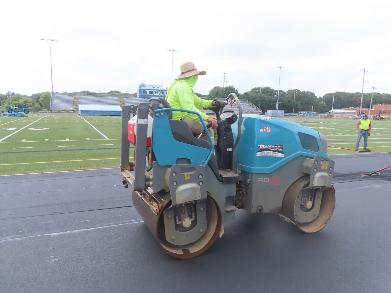 Athletic Surface Base Paving project in Southington, CT — roller on track at football field