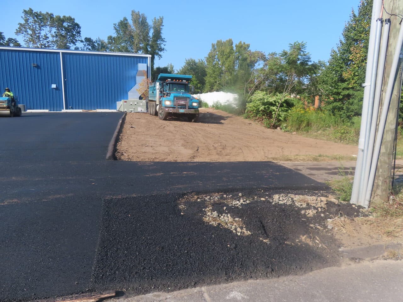 Commercial Parking Lot Paving project in Plainville, CT — truck dumping fill on dirt edge