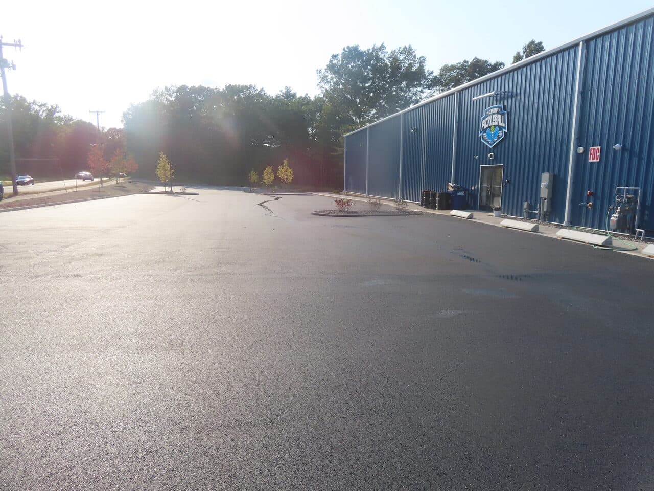 Commercial Parking Lot Paving project in Plainville, CT — finished lot beside blue building